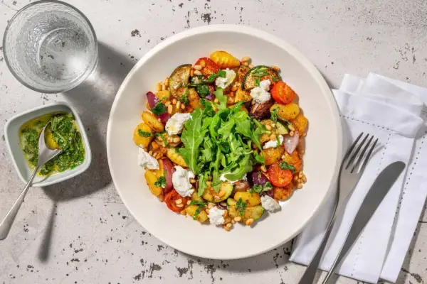 En härlig ugnsrostad grönsaksrätt med potatis, zucchini, tomater och lök, toppad med ricotta och pinjenötter. Ett perfekt ricotta recept för en lätt middag.