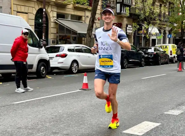 Nathan corre i 10 km in gara, salutando con la mano. Il tempo è ancora da definire, ma la sua energia è palpabile.