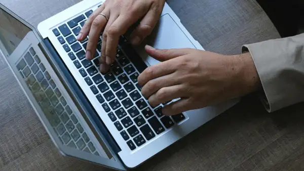 Dłonie piszą na klawiaturze laptopa. W stresującej sytuacji musimy się wszyscy uspokoic i skupić na zadaniu.