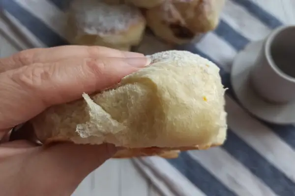 Morbida brioche con lievito madre, cosparsa di zucchero a velo, pronta per essere gustata con un caffè.