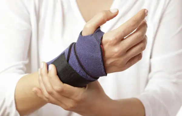Mano con tutore viola per supportare i movimenti del polso.