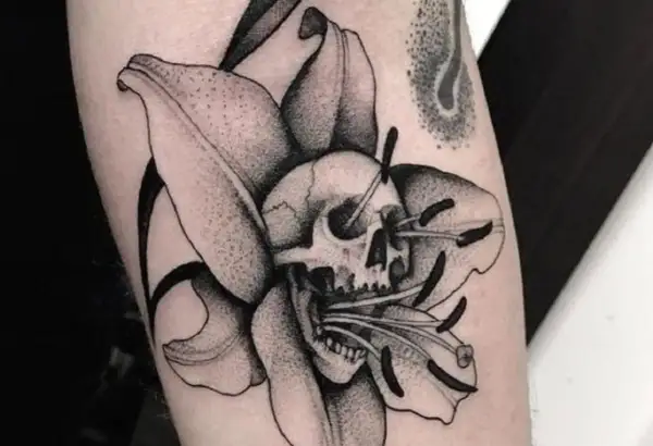 Tatuaże więzienne kropki: czaszka w lilii, symbolizująca przemijanie.