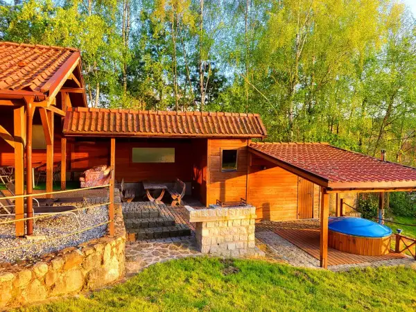 Drewniane domki na Mazurach z bali, zadaszone jacuzzi i grillem. Idealne na tani wypoczynek.