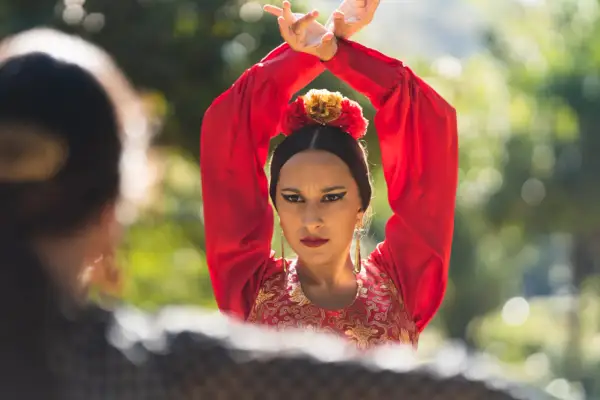 Una bailaora de flamenco, con su vestido rojo y sus **manos flamencas** en alto, transmite pasión y arte.