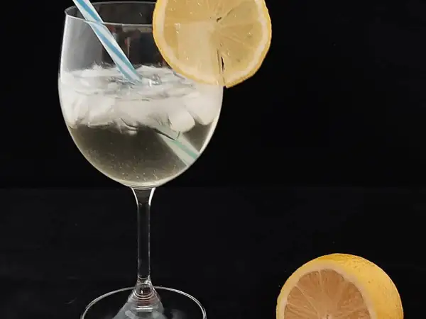 Un verre de spritz saint germain, glacé et garni d'une tranche de citron, prêt à être dégusté.