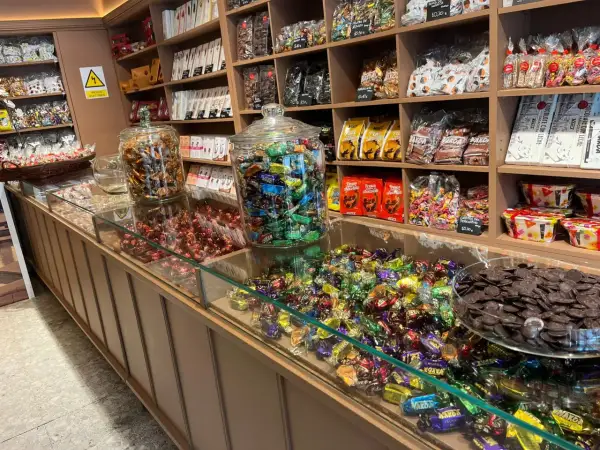 Dulces tentaciones en la fábrica de chocolate Zaragoza. Chocolates, caramelos y bombones en vitrinas y estanterías.