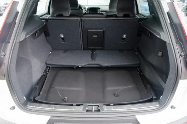 Pusta przestrzeń bagażowa Volvo XC60. Widoczne składane siedzenia i podłoga bagażnika, co pozwala ocenić jego wymiary.