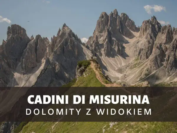 Majestatyczne szczyty Cadini di Misurina w Dolomitach, z wąską ścieżką prowadzącą na zielony pagórek.