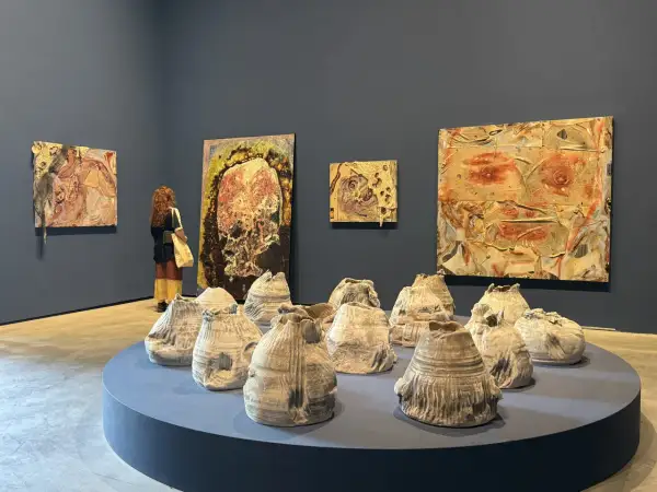 A visitor contemplates abstract artworks and ceramic sculptures at the Venice Biennale 2026.