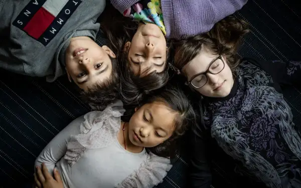 Fyra barn ligger tätt ihop. En 8-åring har svårt att somna, medan de andra verkar sova.
