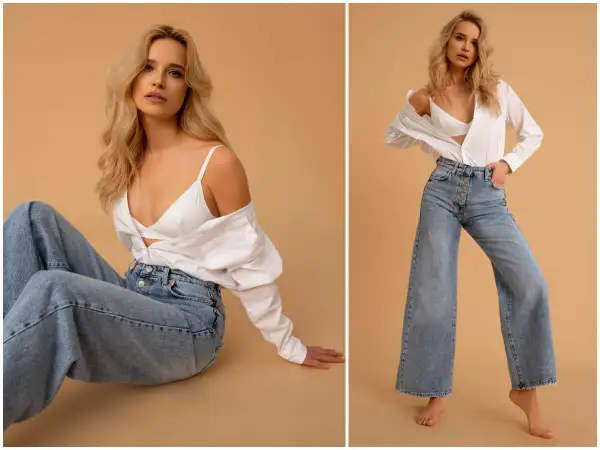 Blondynka w szerokich jeansach i białej koszuli. Stylizacja, która będzie modna w 2023 roku, to luźne fasony i klasyczne połączenia.