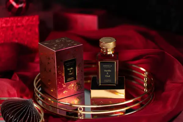 Eleganckie perfumy Sorvella Vanilla & Oud w czerwonym, złotym opakowaniu, otoczone luksusowym materiałem. Trwale perfumy, które podkreślą Twój styl.