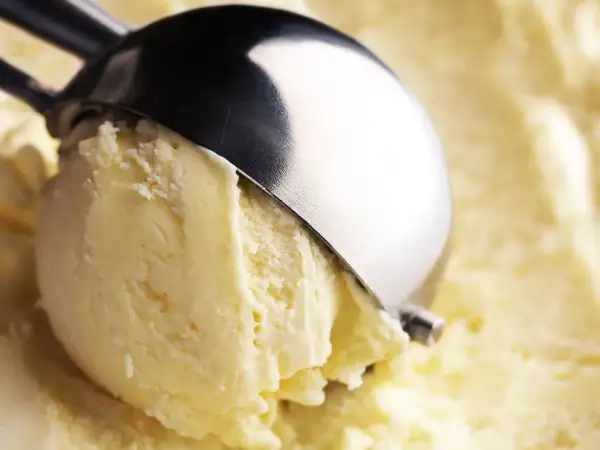Un cucchiaio raccoglie un cremoso gelato, con un sapore che ricorda il latte condensato.