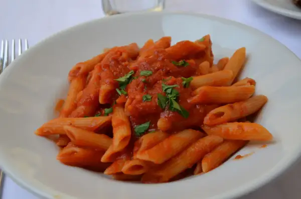 En tallrik med penne arrabiata, en kryddig tomatsås som betyder "arg" på italienska. Garnerad med färsk persilja.