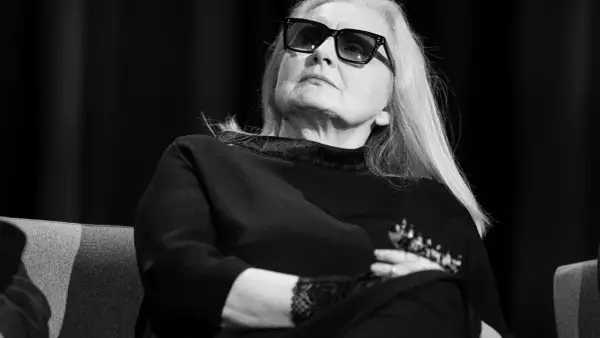 Magda Umer w okularach, z długimi blond włosami, siedzi z rękami skrzyżowanymi na piersi. Jej piosenki magdy umer alfabetycznie mogłyby być tematem tej rozmowy.