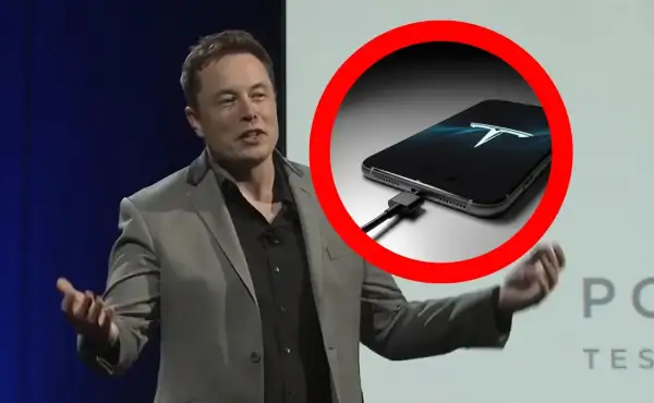 Elon Musk prezentuje telefon z logo Tesli, podłączony do ładowania.