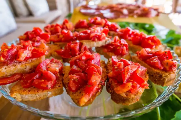 Pyszne bruschetta z pomidorami, czosnkiem i bazylią na chrupiących grzankach. Idealna przekąska na letnie przyjęcie.