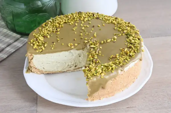 Una deliziosa cheesecake al pistacchio, con una copertura cremosa e granella di pistacchi croccanti, pronta per essere gustata.