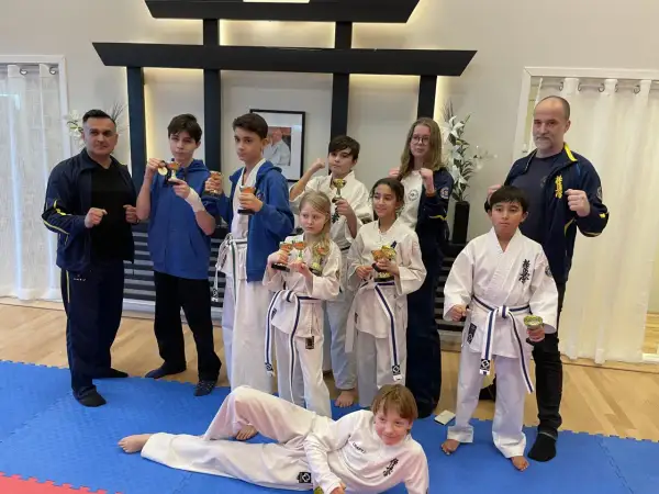 Stolta barn med pokaler efter träning i Oyama Karate Kai. Tränare och elever firar framgångar.