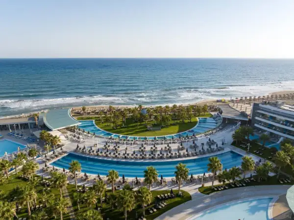 Traumhafter Blick auf das Lyttos Mare auf Kreta: Palmen, Pools und das azurblaue Meer.