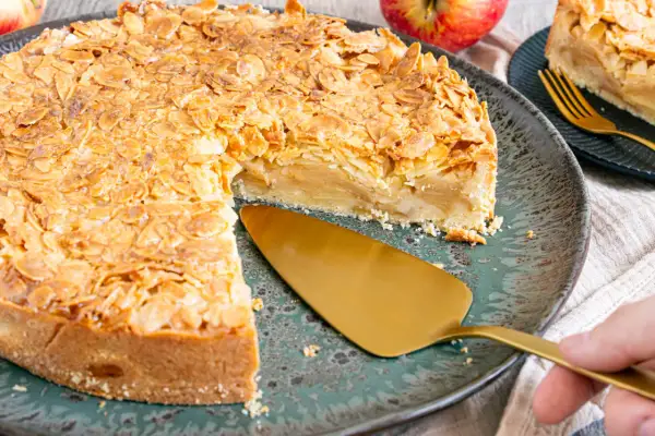Ein goldbrauner Florentiner Apfelkuchen mit knuspriger Mandelkruste, bereit zum Servieren.