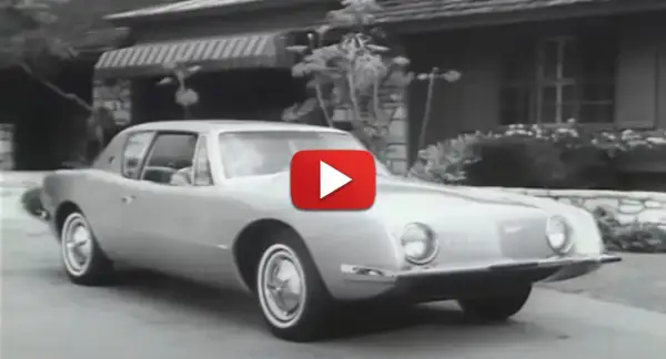 En Studebaker Avanti glider framför ett hus.