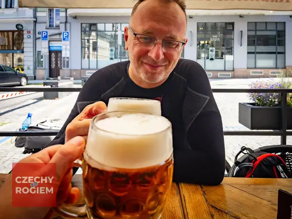 Dwóch mężczyzn wznosi toast pysznym czeskim piwem w słoneczny dzień.