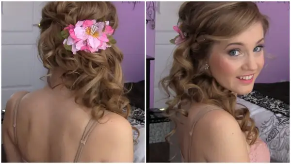 Acconciatura laterale capelli medi con boccoli morbidi e un fiore rosa.