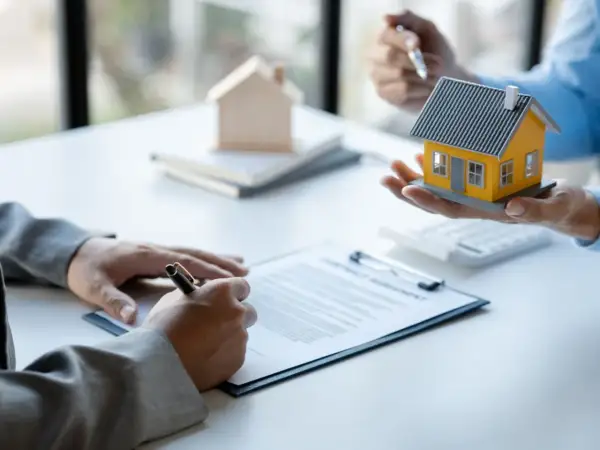 Firma di un contratto di comodato d'uso oneroso con una casa modello in mano.