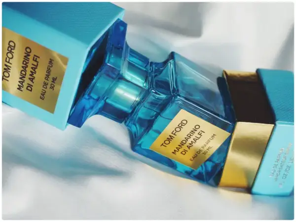 Błękitne pudełko i szklana butelka perfum Tom Ford Mandarino di Amalfi, emanujące świeżością włoskiego wybrzeża.
