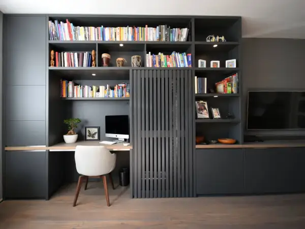 Gemütliche arbeitsecke im wohnzimmer mit Schreibtisch, Computer und Bücherregal.