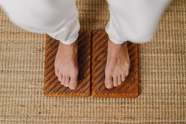 Voeten staan op spijkermat, een oefening voor balans en ontspanning.