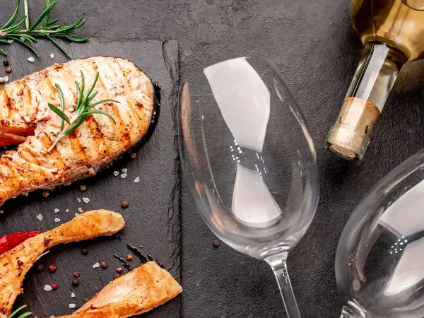 Gegrillter Lachs mit Rosmarin und Pfefferkörnern, bereit für die perfekte Weinbegleitung. Welcher Wein zu Lachs passt, fragst du dich?