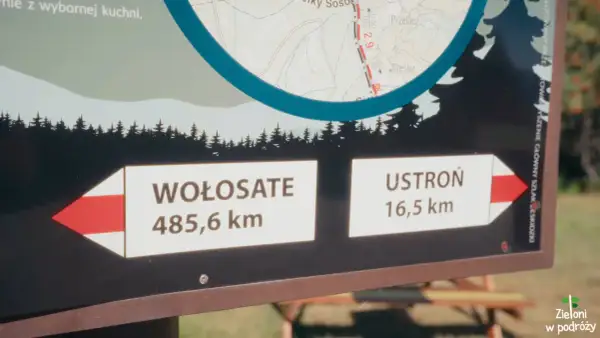 Tablica informacyjna na głównym szlaku bieszczadzkim. Wskazuje odległości do Wołosate (485,6 km) i Ustronia (16,5 km).
