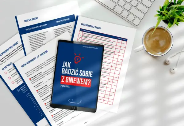 Jak radzić sobie z gniewem? Poradnik na tablecie, obok kubek kawy i słuchawki.