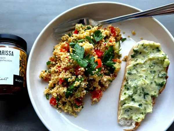 Frischer Couscous-Salat mit Tomaten, Gurken und Kräutern, serviert mit Kräuterbutterbrot. Ein tolles Couscous-Salat-Rezept für den Sommer.