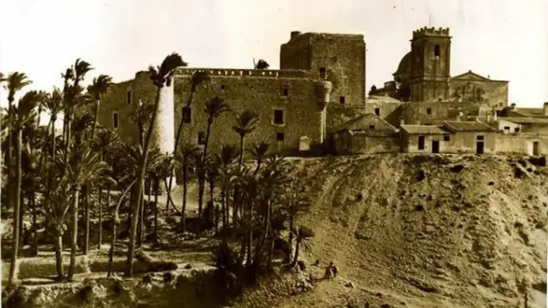 Las torres de Altamira se alzan majestuosas sobre una colina, rodeadas de palmeras. Un antiguo castillo y una iglesia vigilan el paisaje.