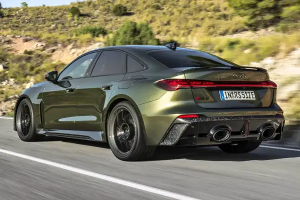 Nowy Audi RS5 2026 w kolorze oliwkowym pędzi po krętej drodze, prezentując sportowy design i moc.