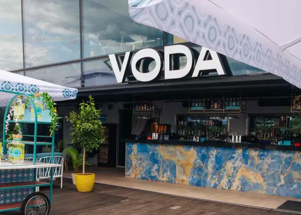 Warszawa knajpy z klimatem: bar VODA z niebieskim marmurowym blatem i butelkami ginu na wózku.