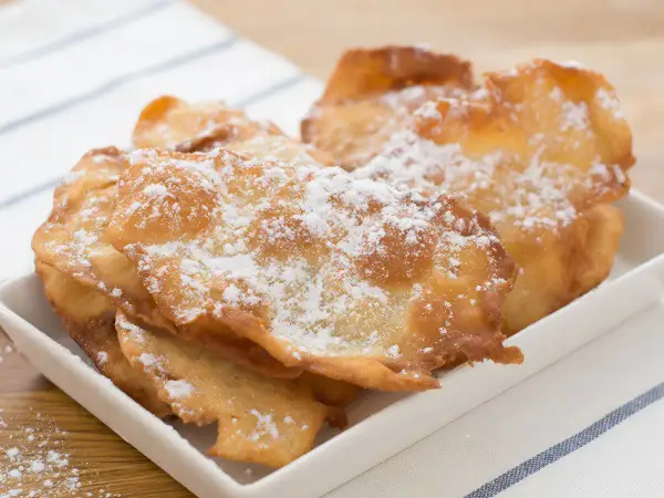 Orejas de carnaval receta gallega, crujientes y espolvoreadas con azúcar glas, listas para disfrutar.