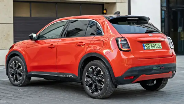 Pomarańczowy Fiat 600 z czarnymi dodatkami i felgami. Sprawdź aktualną fiat 600 cena i dowiedz się więcej o tym stylowym samochodzie.