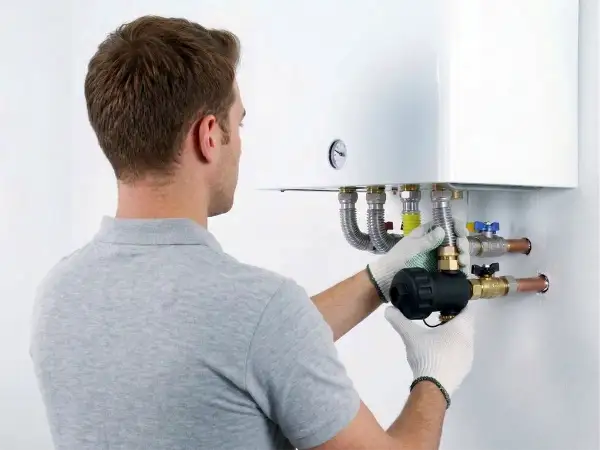 Tecnico installa componente su caldaia, assicurando la garanzia condizionatori.