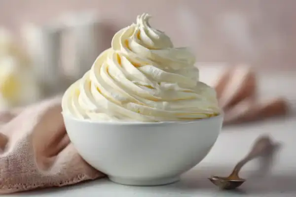 Une délicieuse crème au beurre meringue suisse, aérienne et onctueuse, dressée dans un bol blanc.