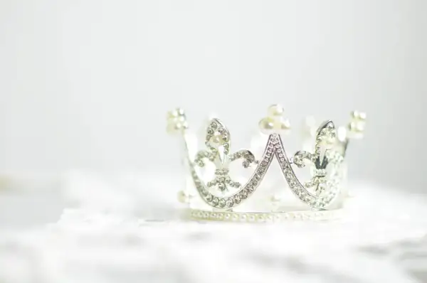 Srebrna korona ozdobiona perłami i kryształkami. Symbolizuje siłę, władzę i piękno, często wybierana jako tatuaż korona znaczenie.