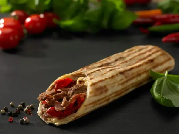 Pyszny kebab z mięsem i papryką, idealny na szybki posiłek. Zastanawiasz się, ile kosztuje kebab?