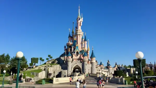 El castillo de la Bella Durmiente se alza majestuoso bajo un cielo azul, invitando a la fantasía.