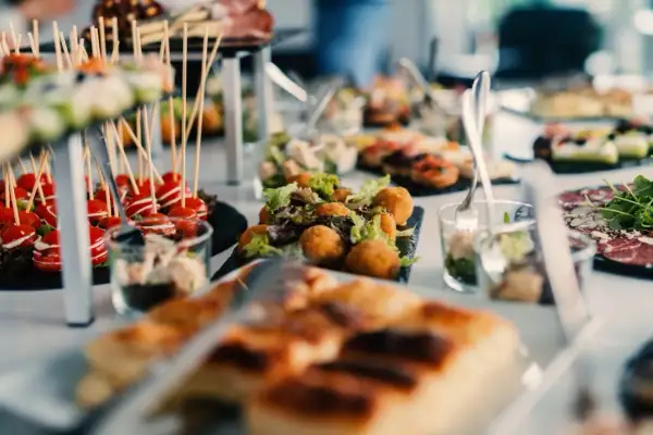 Un apéro dinatoire enceinte, avec des verrines, des brochettes de tomates cerises, des boules de fromage et des tartines.