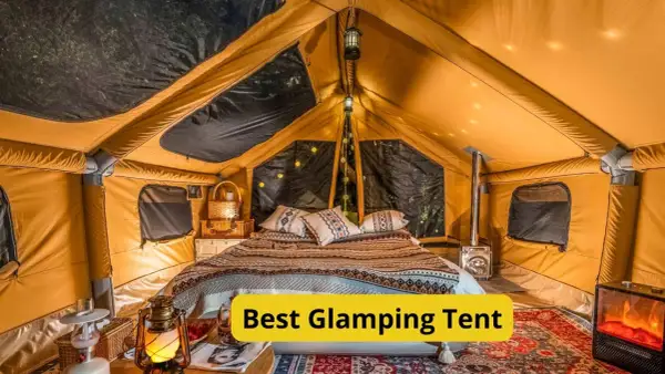 Wnętrze luksusowego namiotu glampingowego z wygodnym łóżkiem, piecykiem i nastrojowym oświetleniem. To jest właśnie glamping co to znaczy – komfort na łonie natury.