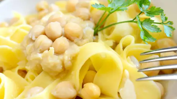 Ciceri e tria, un piatto pugliese con pasta fresca e ceci, guarnito con prezzemolo.