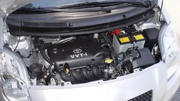 Silnik Toyoty Yaris II z widocznym akumulatorem i elementami osprzętu.